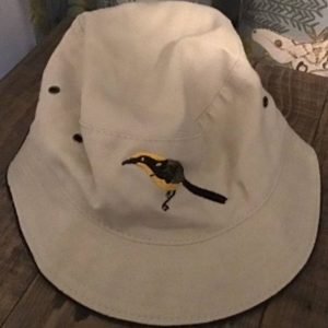 beige bucket hat with emrboidered helmeted honeyeater image
