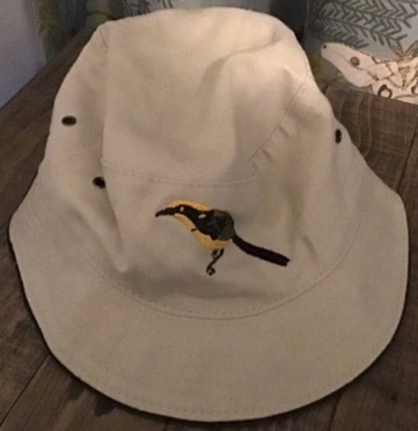 beige bucket hat with emrboidered helmeted honeyeater image